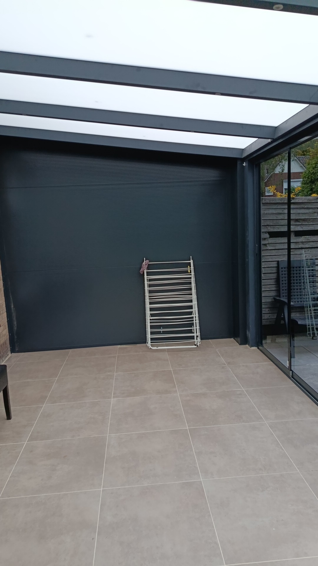 Veranda met antraciet paneelwand en glazen schuifwand
