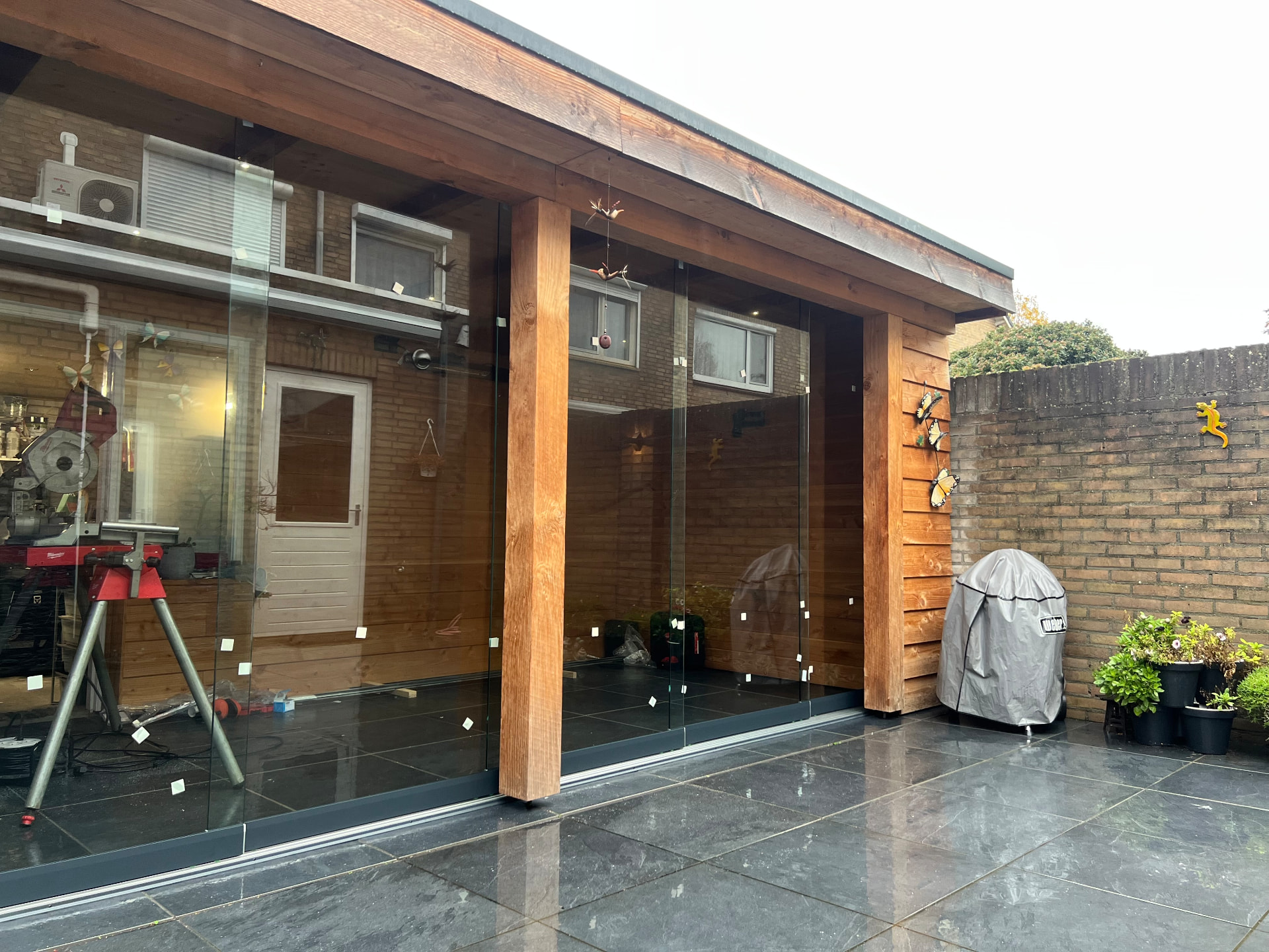 Heldere glazen schuifwand bij een houten veranda