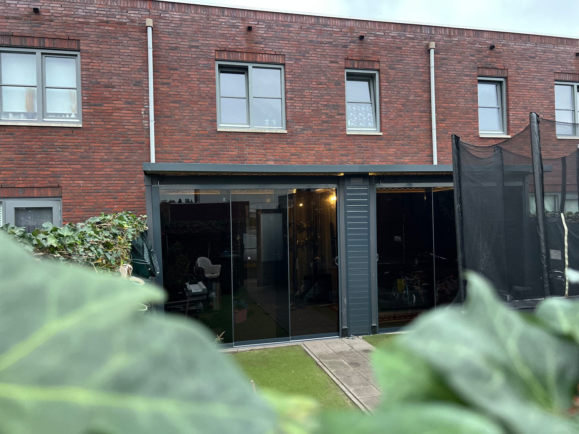 Donkere glazen schuifwand bij een moderne tuinkamer
